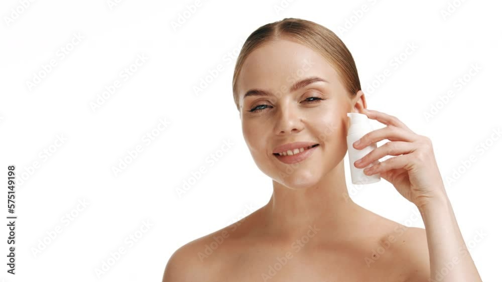 Slow motion portrait young woman uses creams of her face. Concept for fresh moisturized skin beautiful closeup cosmetic face happy healthy model. Young blonde hair woman take care of her skin Slow motion portrait young woman uses creams of her face. Concept for fresh moisturized skin beautiful closeup cosmetic face happy healthy model. Young blonde hair woman take care of her skin