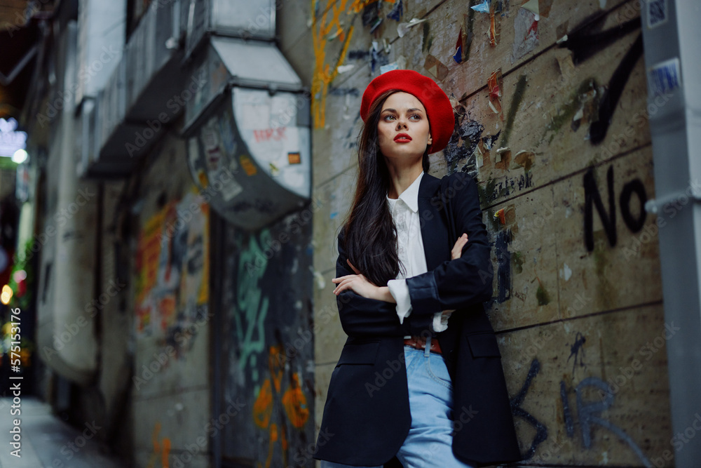 Fashion woman portrait walking tourist in stylish clothes with red lips walking down a narrow city street, travel, cinematic color, retro vintage style, dramatic against a wall with graffiti. Fashion woman portrait walking tourist in stylish clothes with red lips walking down a narrow city street, travel, cinematic color, retro vintage style, dramatic against a wall with graffiti.