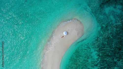 Aerial Top Downward Shot Of Woman Relaxing By Parasol At Beach Island Amidst Turquoise Sea Coastline During Vacation - Thulusdhoo, Maldives photo