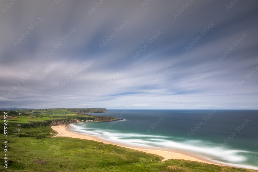 Whitepark Bay Beach and Portbradden Harbour with cliffs, sandy beach, blurred water and sky on long exposure. Causeway Coast, Antrim, Northern Ireland