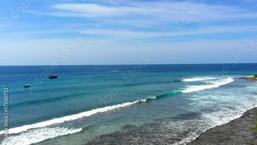 Aerial Forward Shot Of Tourists Surfing On Waves In Sea Under Sky At Vacation During Sunny Day - Thulusdhoo, Maldives photo