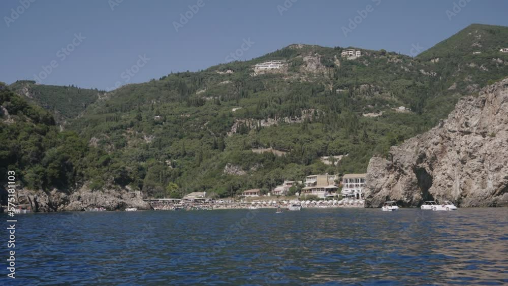 Paleokastritsa beach and village on Corfu island, Greece. Picturesque seashore with turquoise crystal water, pebble beach Agios Spiridon, mountains and cliffs Paleokastritsa beach and village on Corfu island, Greece. Picturesque seashore with turquoise crystal water, pebble beach Agios Spiridon, mountains and cliffs