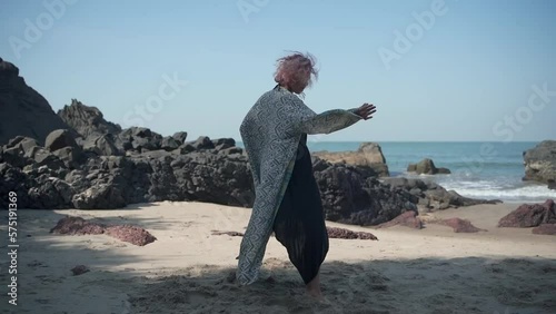 A girl with purple hair makes energetic movements in a beautiful dress
