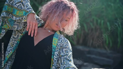 A young lady in a dress performs an uncompromising dance in nature