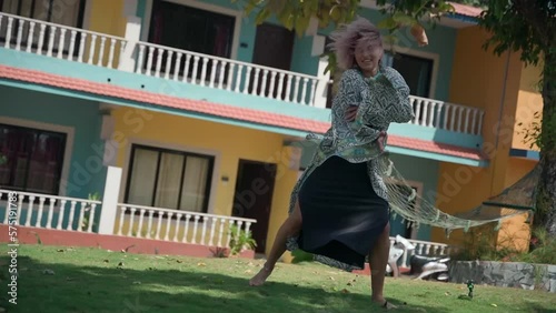 A young lady of European appearance with a purple haircut dances