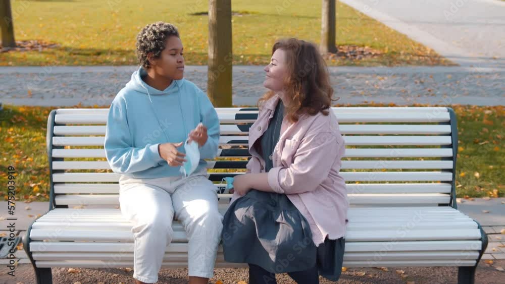 Lesbian couple remove safety mask and kiss outdoors during covid-19