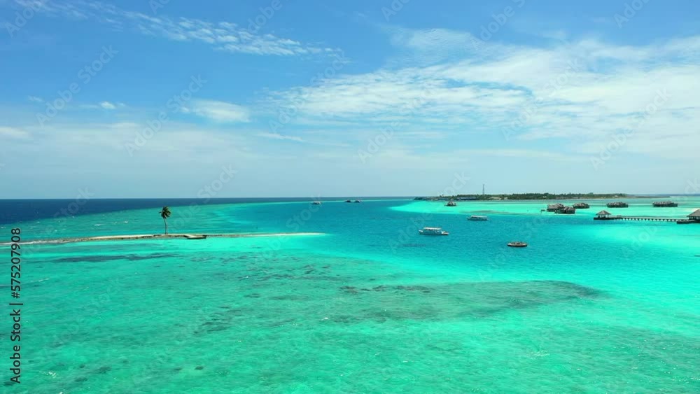 Aerial Shot Of Nautical Vessels Amidst Beach And Tourist Resorts, Drone Flying Forward Over Turquoise Wavy Sea - Thulusdhoo, Maldives Aerial Shot Of Nautical Vessels Amidst Beach And Tourist Resorts, Drone Flying Forward Over Turquoise Wavy Sea - Thulusdhoo, Maldives