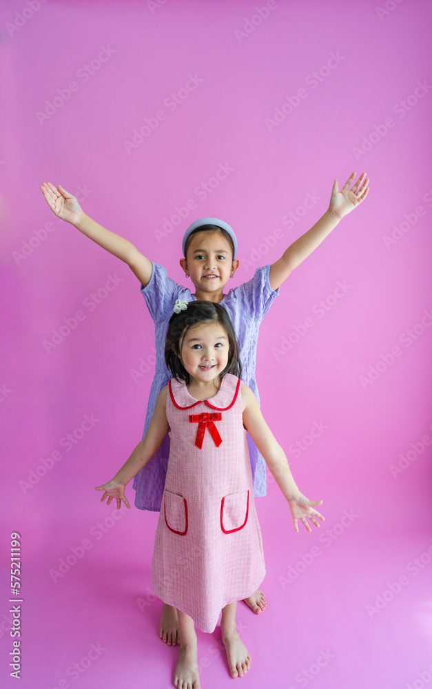 Two pretty little girls standing and reaching up high and low. Two pretty little girls standing and reaching up high and low.