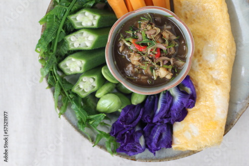 Thai southern spicy Budu salad is anchovies sauce and one of the best known fermented seafood products and herb is a Thai food have a hot and spice in Thai street food market at Bangkok Thailand photo