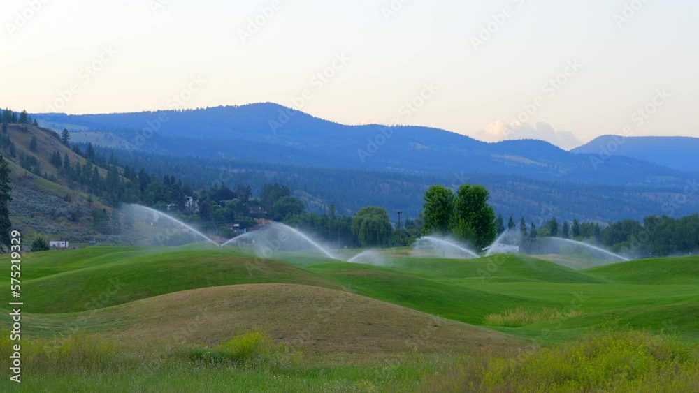 Establishing shot of golf course in service watering with gorgeous green and mountain view in Vancouver, Canada, North America. Day time on May 2022. Still camera. ProRes 422 HQ. Establishing shot of golf course in service watering with gorgeous green and mountain view in Vancouver, Canada, North America. Day time on May 2022. Still camera. ProRes 422 HQ.