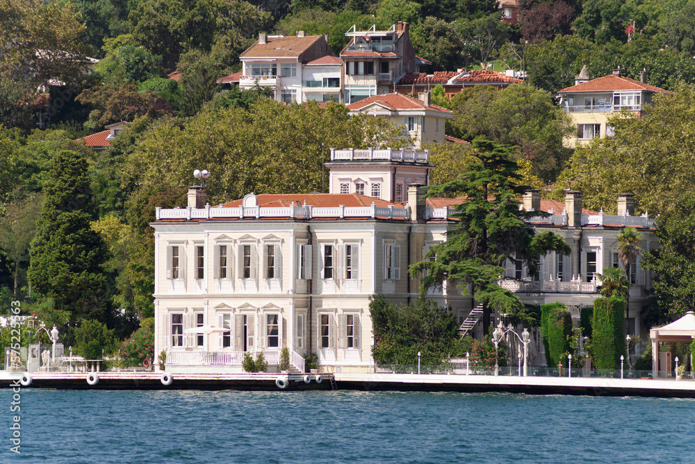 View from the sea of the European side of Bosphorus strait, Istanbul, Turkey, with traditional houses, and green mountains with dense green trees, in a summer day
