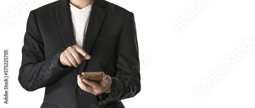 The Asian man in a black suit is standing alone and holding a phone.