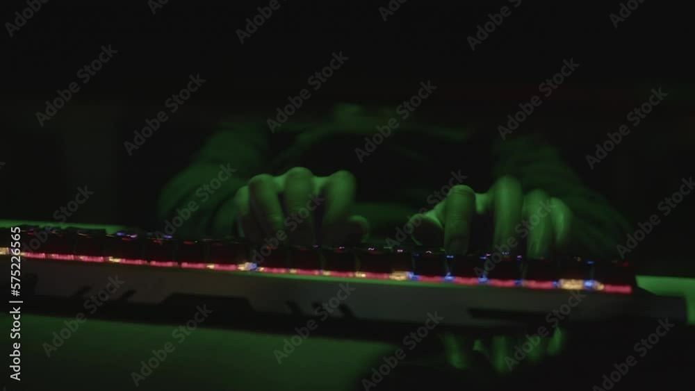 Colorful RGB Keyboard Typing Hacker or Coder Writing Code with Fingers on Green Light