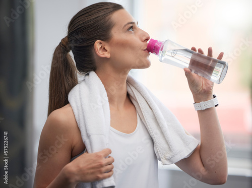 Fitness, woman and drinking water in gym for health, break and energy for workout, training or towel. Thirsty sports person, female and hydration with bottle, exercise nutrition and training wellness