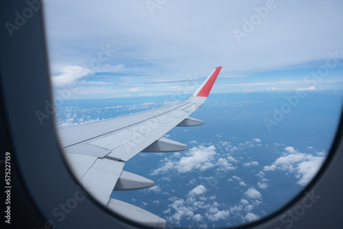 Airplane wing flying above the sky with white clouds. View from aircraft window. flying and traveling concept.