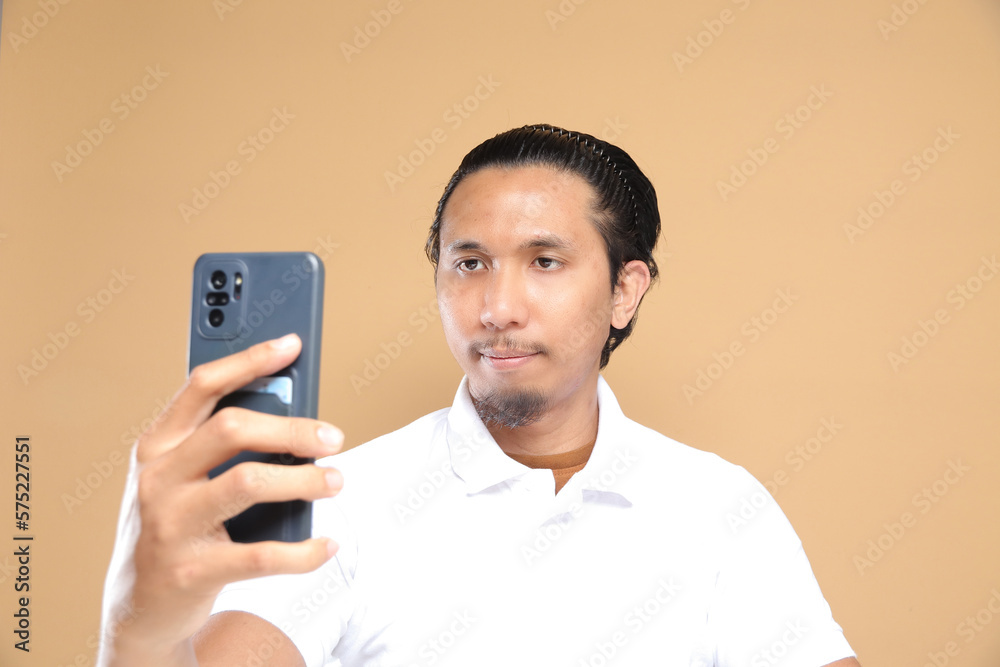 Asian male holding mobile phone. Technology concept. Asian male holding mobile phone. Technology concept.
