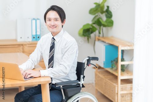 車椅子に座り仕事をするビジネスマン 
