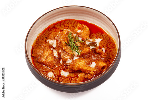 Panang pork curry with coconut milk and sliced kaffir lime leaves in a bowl isolated on white background, Panang curry is a very popular Thai dish.