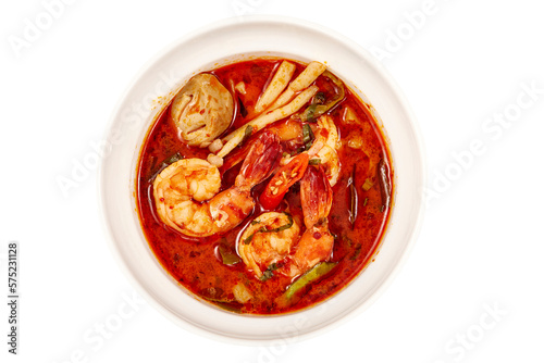 Top view of Creamy Tom Yum Kung Soup, That is a very popular dish in Thailand, containing of vegetables and herbs such as chili, lemongrass, lime leaves, lime and mushrooms.