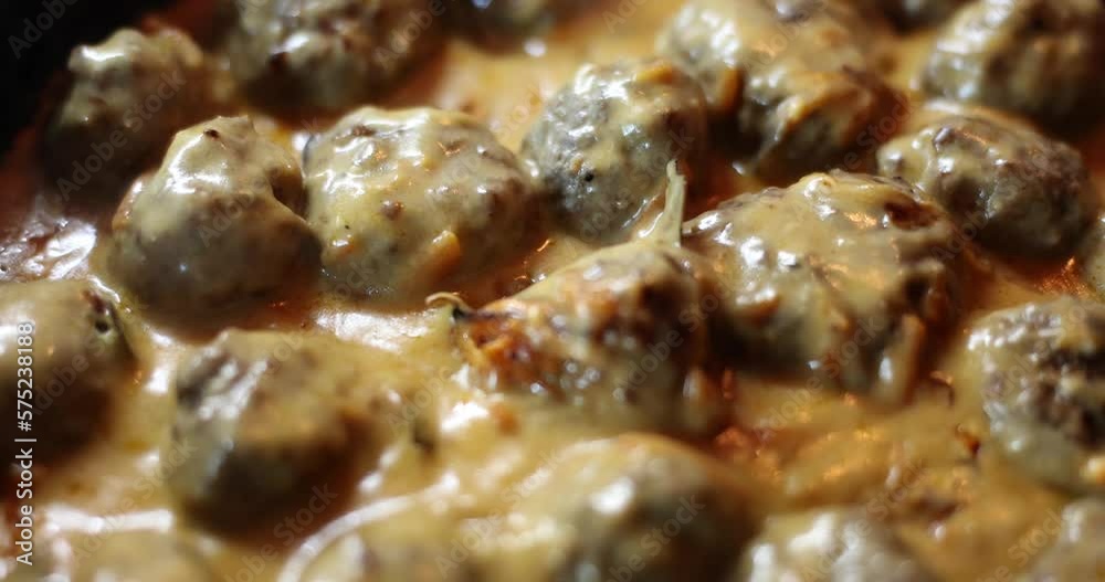 Delicious homemade swedish meatballs with creamy white sauce in frying pan