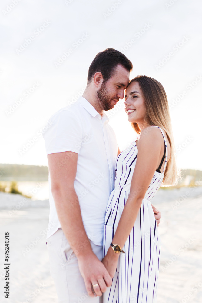 man and a woman are hugging on a sandy beach in summer man and a woman are hugging on a sandy beach in summer