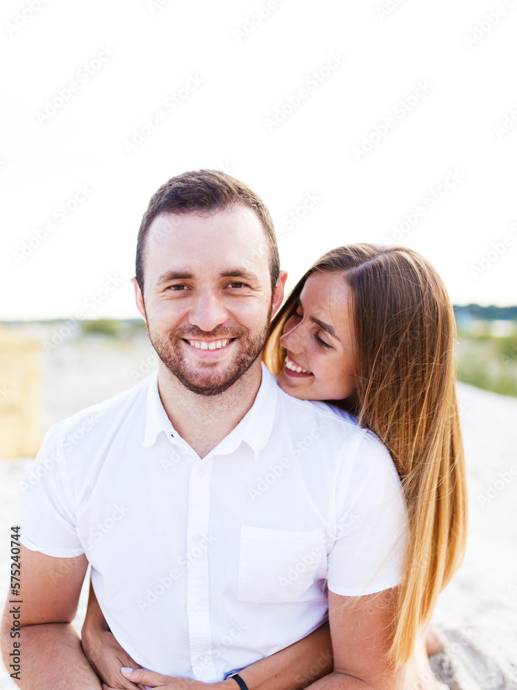 Fototapeta premium man and a woman are hugging on a sandy beach in summer