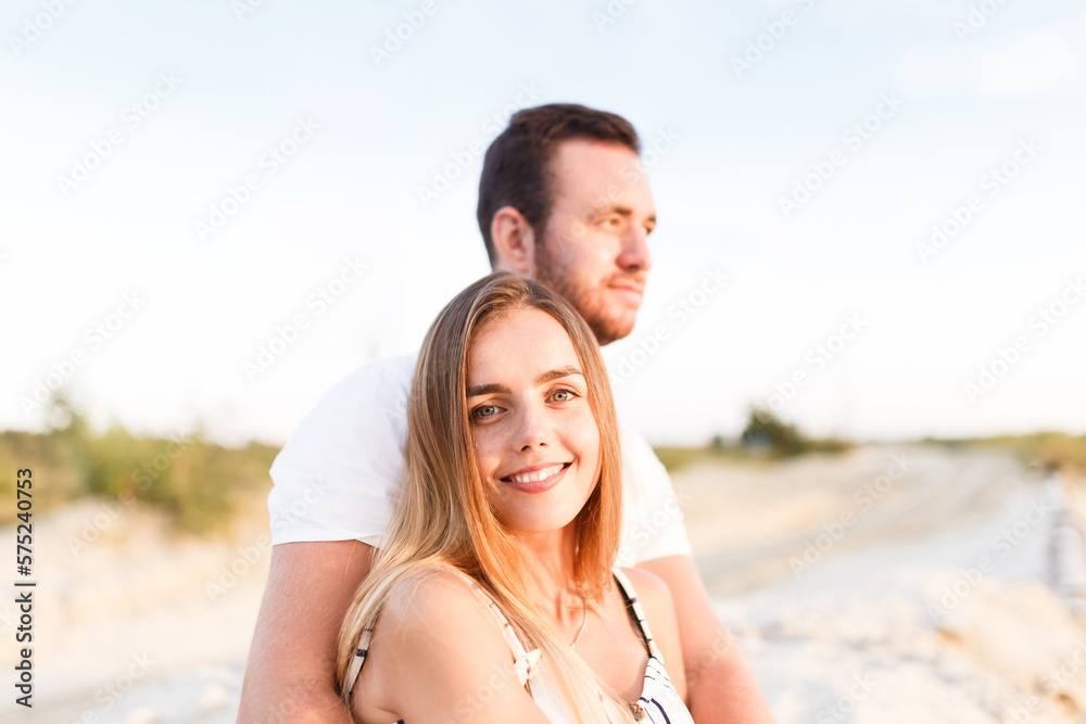man and a woman in light clothes are laughing together on the beach man and a woman in light clothes are laughing together on the beach