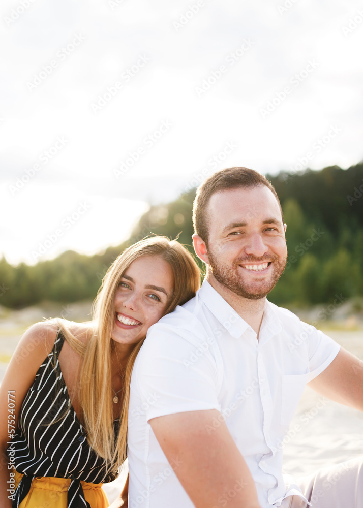 young couple in love are sitting on a sandy beach on vacation young couple in love are sitting on a sandy beach on vacation