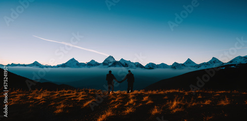 Silhouette of two person on top of mountain peak. / Holding Hands / coaching goal, success and teamwork concepts - Mountains Mountaineer / Space for Text / Blank Space / Copy Text photo