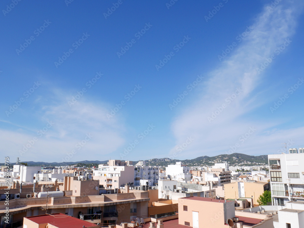 Blue sky, white buildings and sun in Ibiza town