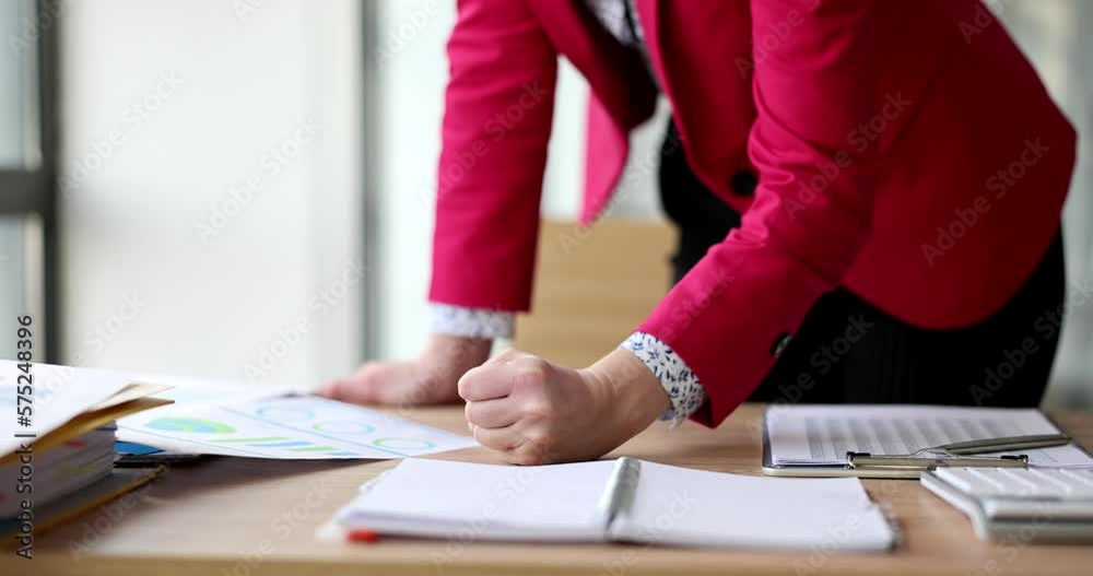 Seo businesswoman banging fist on financial report in anger Seo businesswoman banging fist on financial report in anger