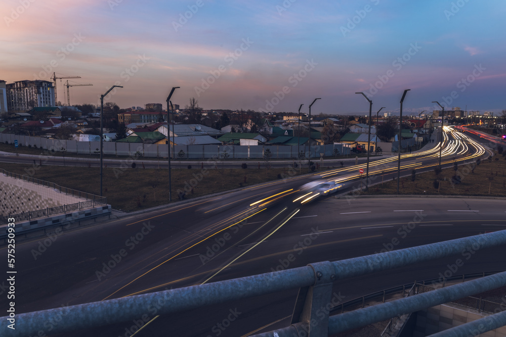 City road with traffic of cars with trail from lights and bridge