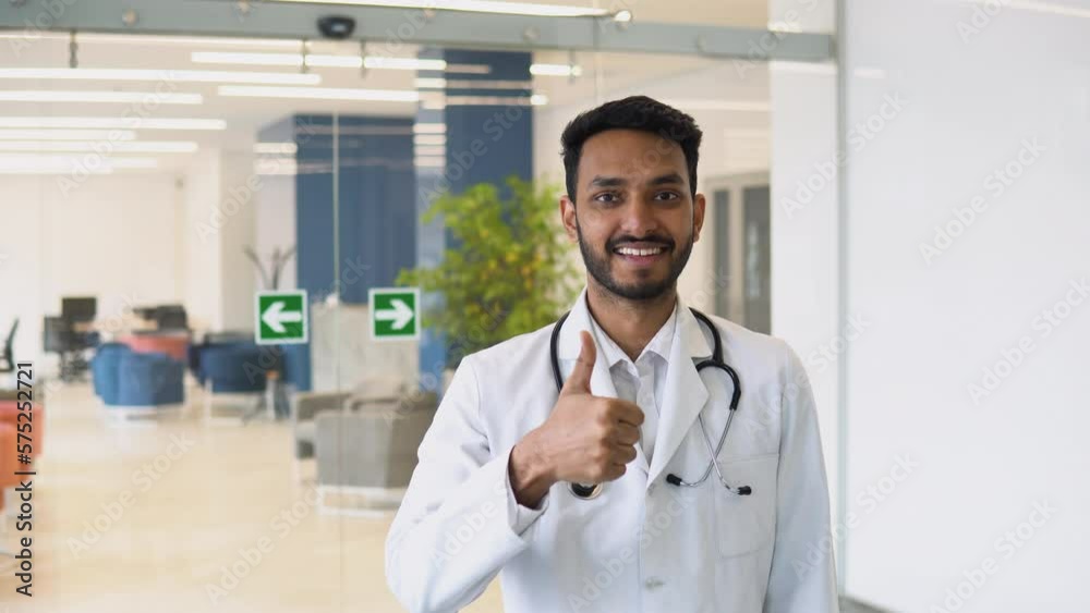 Happy young indian male doctor shows thumbs up sign Happy young indian male doctor shows thumbs up sign