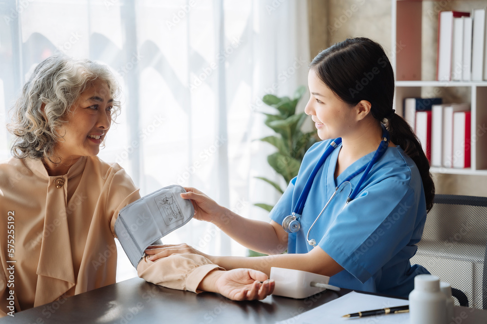 Female doctor having blood pressure test elderly woman at the clinic in the morning. Female doctor having blood pressure test elderly woman at the clinic in the morning.