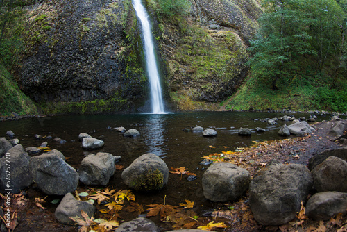 Horsetail Falls and mossy canyon wall with fall leaves on shoreline, Columbia Gorge, Oregon. photo