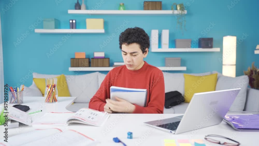 Male student bored and angry with distance education at home.
Frustrated and unhappy male student is bored with distance online classes for his education.
