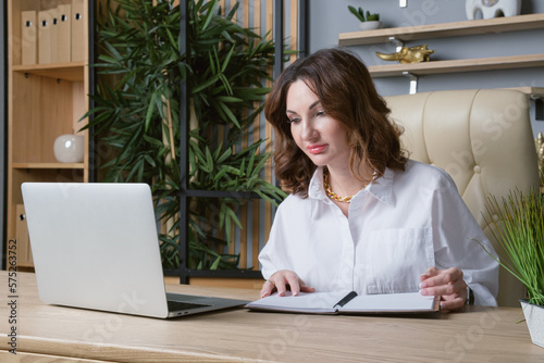 Portrait of a business woman in a white blouse at desk