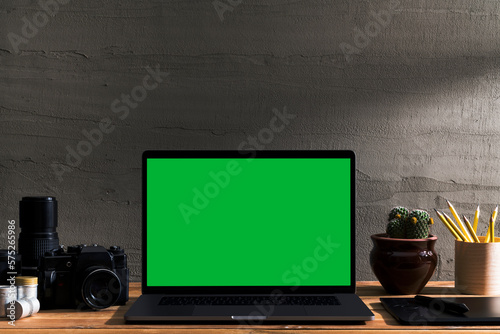 Chroma key green screen laptop on table with film camera and film rolls