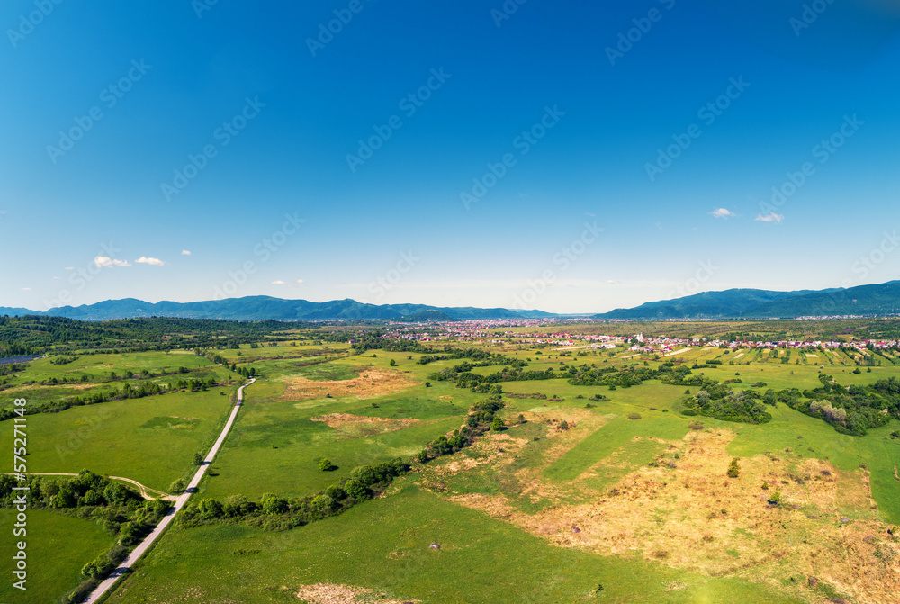 Drone view of the countryside. Road, meadows, and the village in the foothills of the Carpathians