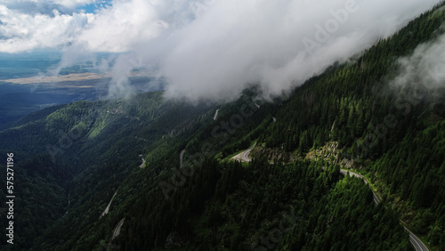 Amazing roads of the world. Aerial view over Transfagarasan landmark road of Romania, waving through the landscape of Fagaras Mountains in a cloudy day with fog coming out of the forest.