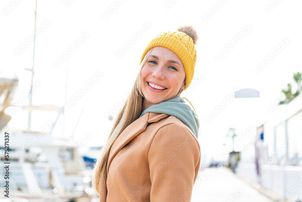 Young blonde woman wearing winter jacket at outdoors with happy expression