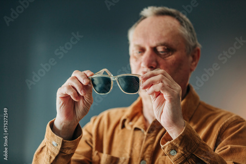 elderly man wearing special glasses for eye training
