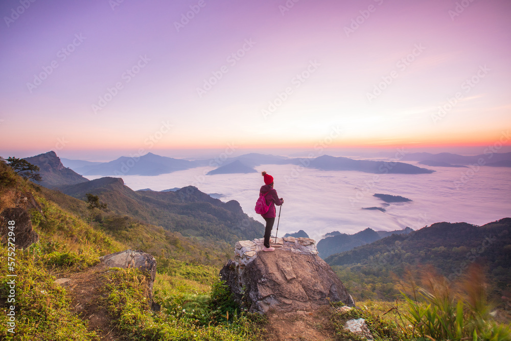 Young woman  in red jacket hiking on the high mountain, Phu Chee Duean, border  of  Thailand and Laos.