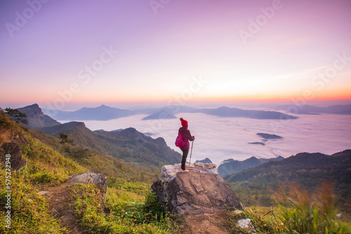 Young woman in red jacket hiking on the high mountain, Phu Chee Duean, border of Thailand and Laos.