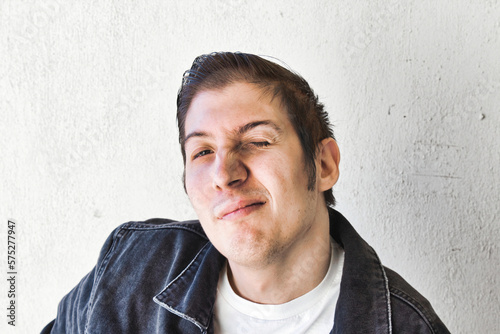 Obraz na plátně Portrait of a young man dressed as a 1960s greaser, with combed back hair and de