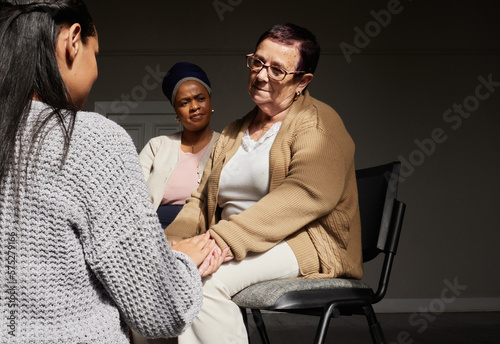 Fototapeta Naklejka Na Ścianę i Meble -  Support, women holding hands and group therapy with understanding, sharing feelings and trust talking in session. Mental health, grief or depression, sad senior woman with therapist sitting together.