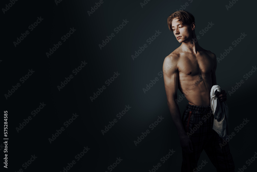slim and bony male body is undress while man hold his white shirt in hand and look to left side to copyspace slim and bony male body is undress while man hold his white shirt in hand and look to left side to copyspace