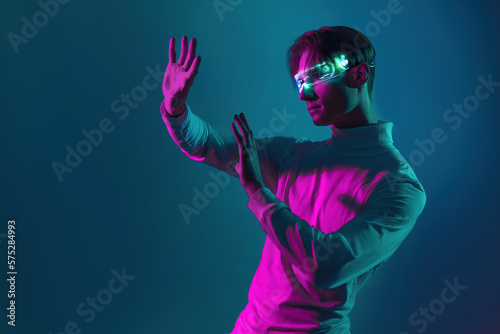 man has virtual experience with hands try to touch the virtual simulation he see on his eyes caused by light of futuristic glasses