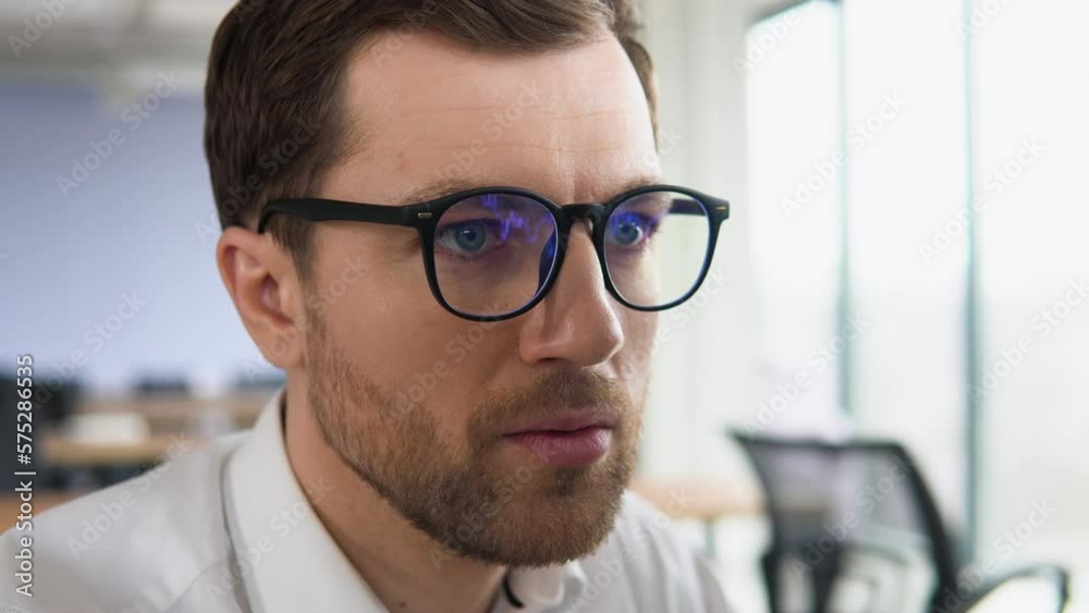Businessman with glasses looks at stock market quotes and exchange rates during the financial crisis Businessman with glasses looks at stock market quotes and exchange rates during the financial crisis