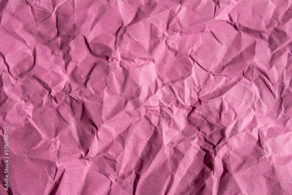 Crumpled pink paper texture background. Wrinkled paper surface for designs.